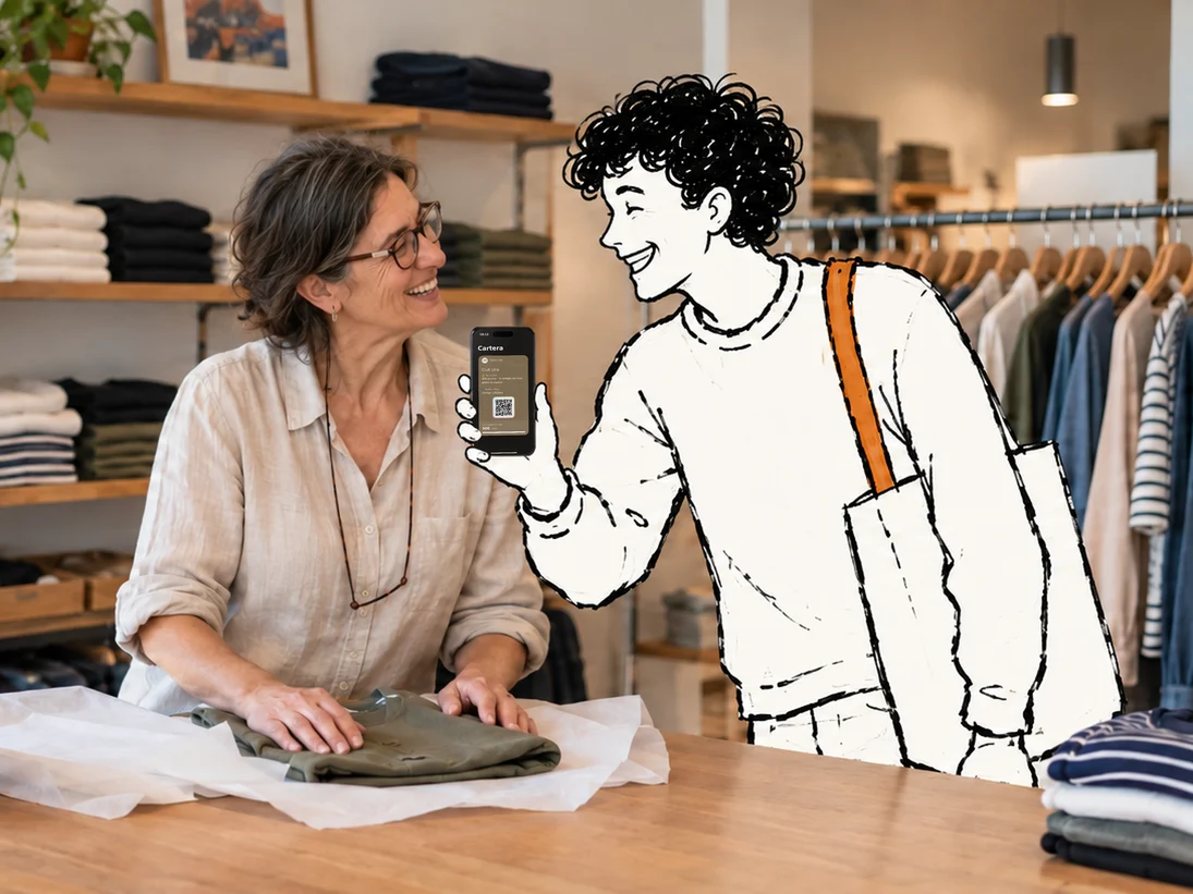 En el mostrador de una tienda de ropa de barrio, Elio, dibujado a tinta, enseña la tarjeta de la tienda en el móvil a la dependienta y los dos se ríen, mientras ella envuelve una camisa en papel de seda.